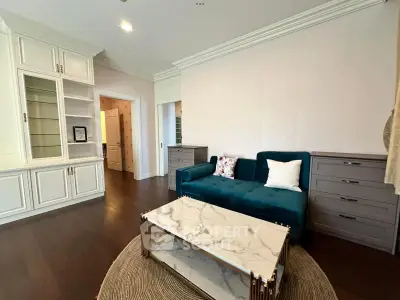 Elegant living room with plush teal sofa, marble coffee table, and built-in shelving for modern comfort.