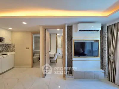 Modern apartment interior with sleek kitchen and stylish living area featuring built-in TV and air conditioning.