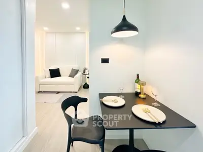Modern dining area with stylish black table and chairs, adjacent to cozy living room.