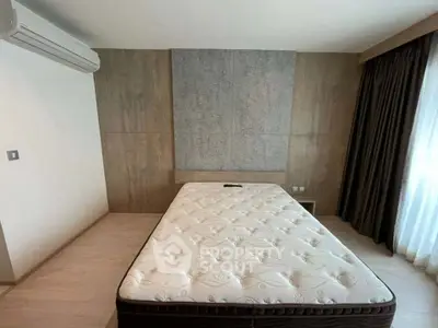 Spacious bedroom with modern design and large window for natural light.