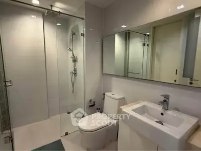 Modern bathroom with glass shower and sleek fixtures in a contemporary home.