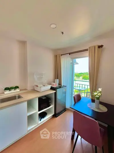 Charming kitchen with dining area and balcony view, featuring modern appliances and elegant decor.