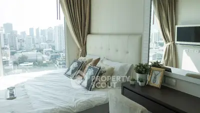 Luxurious bedroom with city view, elegant decor, and natural light in modern apartment.