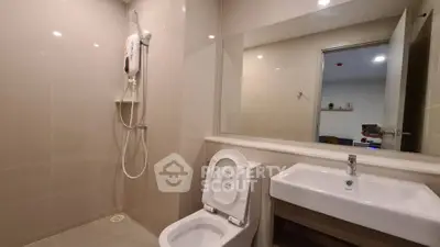 Modern bathroom with sleek fixtures and large mirror in contemporary apartment.