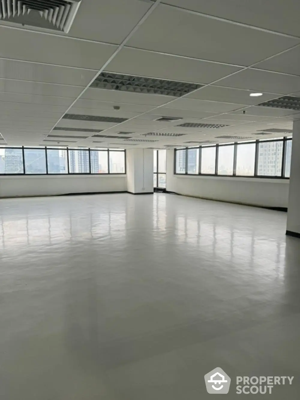 Expansive open-plan office space with abundant natural light from wrap-around windows, ready for a custom layout in a prime location.