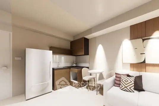 Modern compact kitchen with fridge and cozy seating area in stylish apartment.