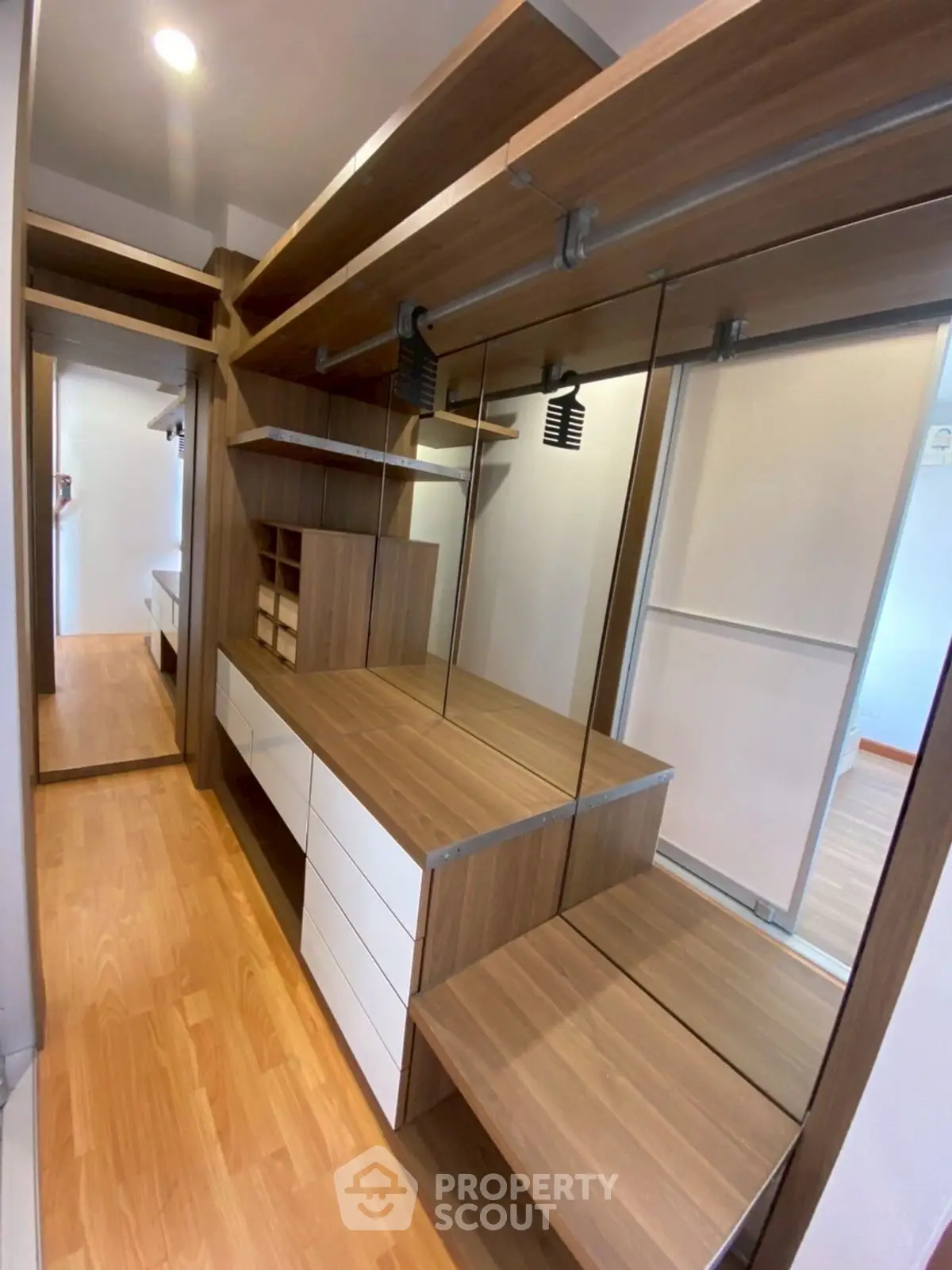 Spacious walk-in closet with modern wooden shelving and ample storage space.