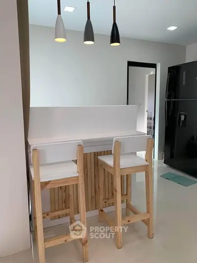 Modern kitchen with wooden bar stools and sleek lighting fixtures