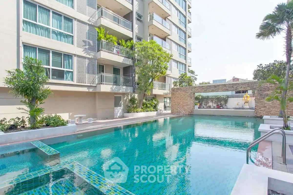 Luxurious condominium with a stunning outdoor pool and lush greenery, perfect for relaxation and leisure.