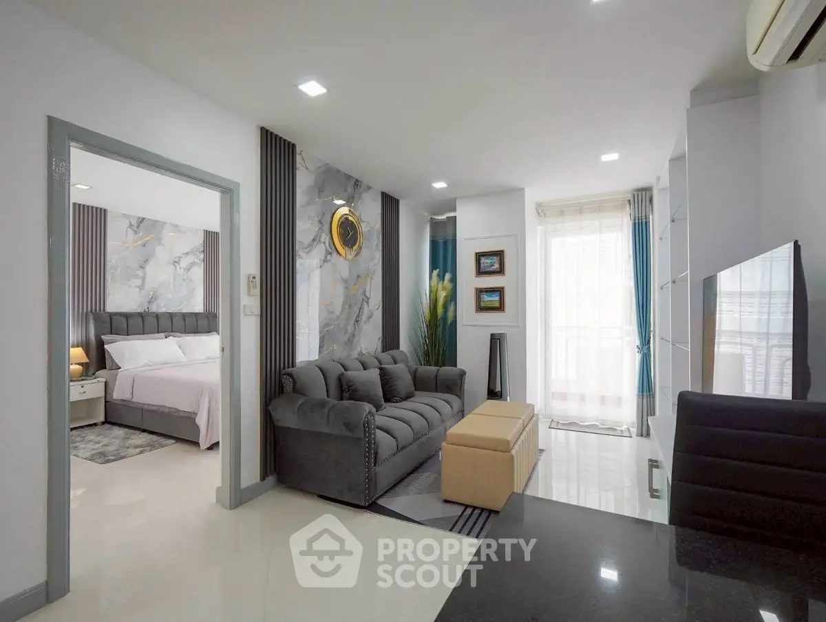 Modern living room with stylish decor and open layout leading to a cozy bedroom, perfect for urban living.