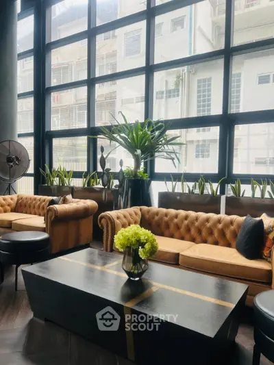 Luxurious living room with elegant sofas and large windows offering urban views.