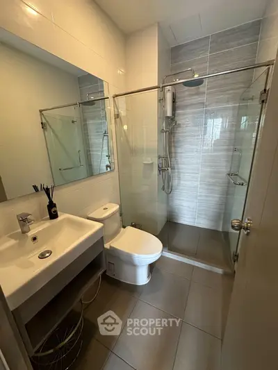 Modern bathroom with glass shower and sleek fixtures in a contemporary home.