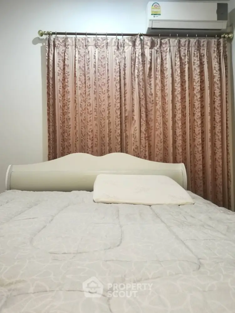 Cozy bedroom with elegant curtains and air conditioning unit