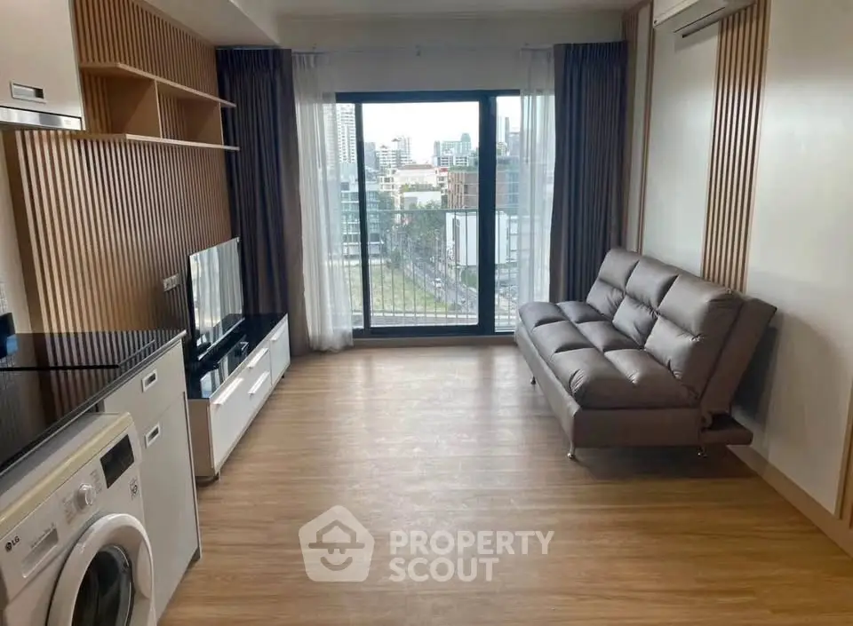 Modern living room with city view, featuring sleek furniture and in-unit washing machine.