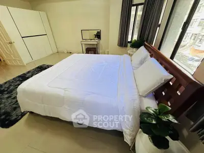 Spacious bedroom with large windows and modern decor in a luxury apartment.