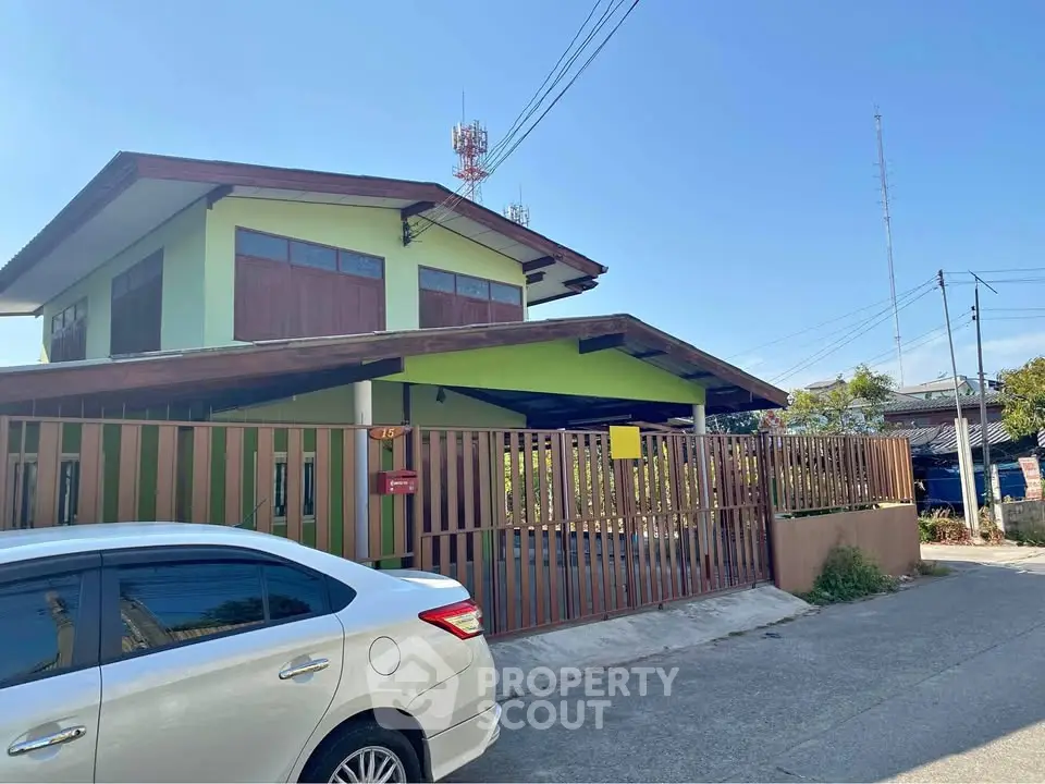 Charming two-story house with wooden accents and gated driveway in a serene neighborhood.