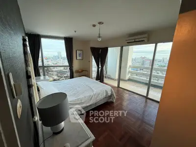 Spacious bedroom with city view and large balcony access in modern apartment