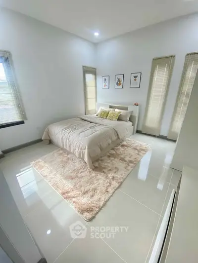 Spacious and bright bedroom with modern decor and large windows