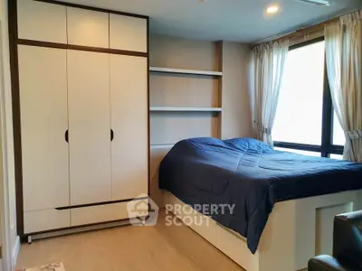 Cozy bedroom with built-in wardrobe and large window for natural light