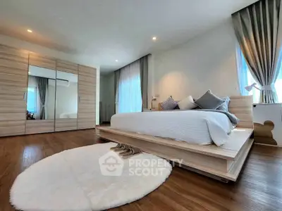 Spacious modern bedroom with elegant wooden flooring and stylish decor