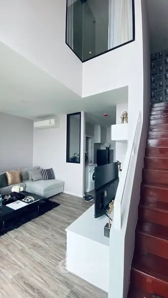 Modern duplex living room with stylish decor and staircase