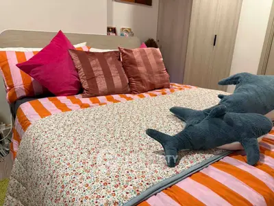 Cozy bedroom with vibrant bedding and plush dolphin toys, perfect for a comfortable and inviting atmosphere.