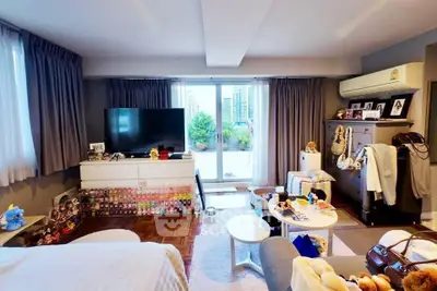 Spacious bedroom with balcony access and modern decor in urban apartment