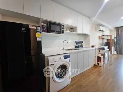 Modern kitchen with sleek appliances and open layout in stylish apartment.