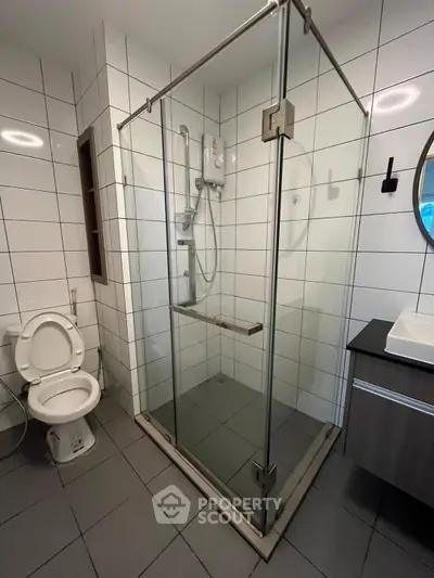 Modern bathroom with glass shower enclosure and sleek fixtures
