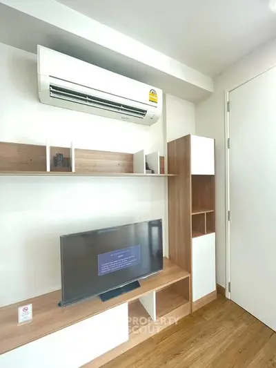Modern living room with sleek air conditioning and stylish TV setup, perfect for comfortable living.