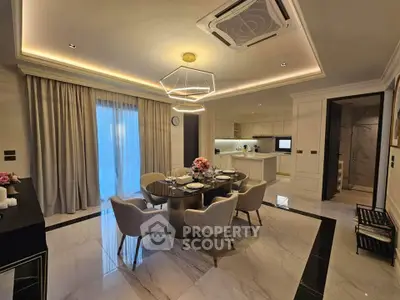 Luxurious dining area with elegant lighting and modern kitchen in open layout apartment.