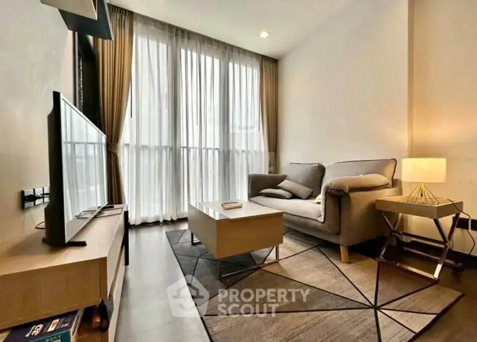 Modern living room with cozy sofa, stylish lamp, and large window for natural light.