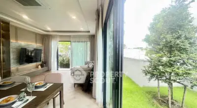 Modern living room with large windows opening to a lush garden, featuring elegant dining setup.