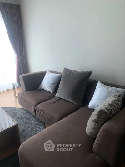 Cozy living room with modern brown sofa and natural light