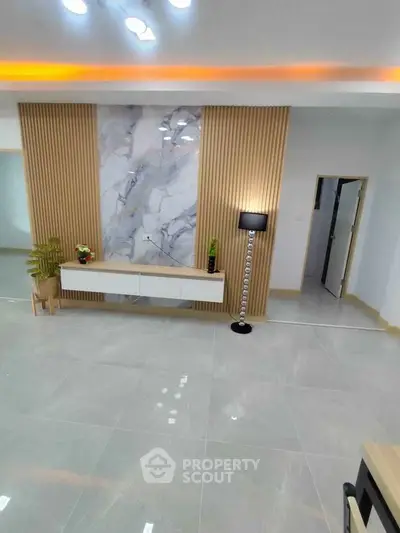 Modern living room with elegant marble accent wall and stylish lighting