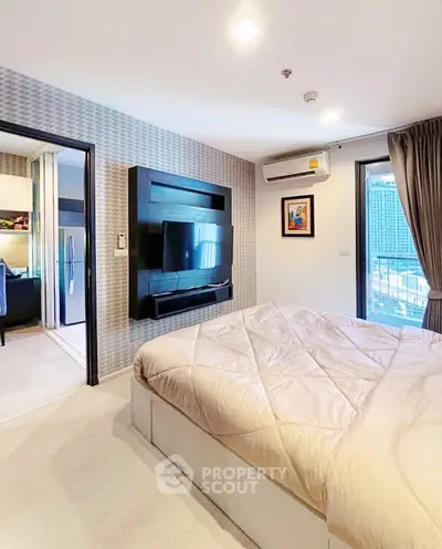 Modern bedroom with stylish decor and city view, featuring a wall-mounted TV and cozy bedding.