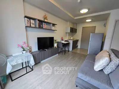 Modern living room with open kitchen, stylish decor, and cozy seating area in a contemporary apartment.