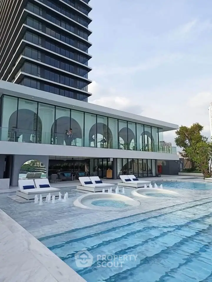 Luxurious modern building with stunning poolside view and elegant architecture.