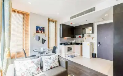 Modern open-layout kitchen and living area with stylish decor and natural light.