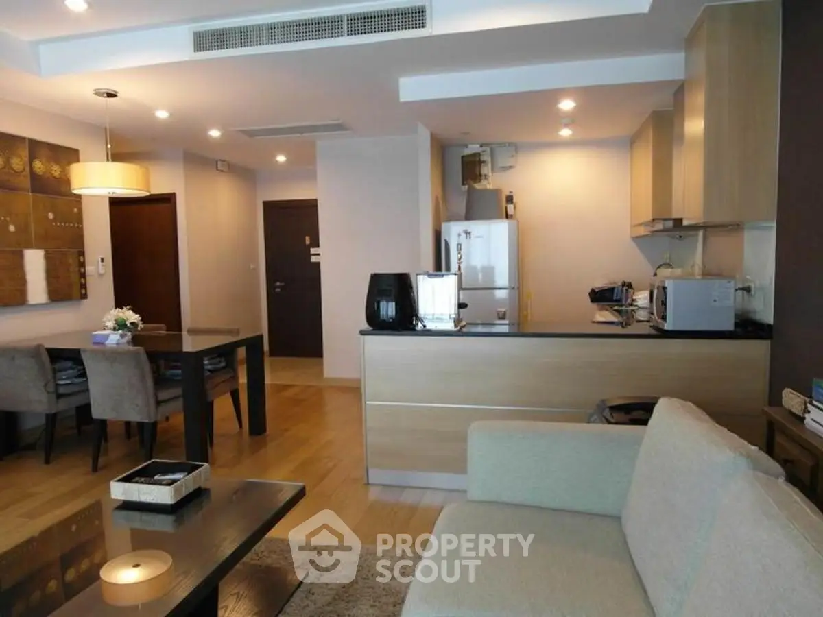 Modern open-plan living room and kitchen with stylish decor and wooden flooring.