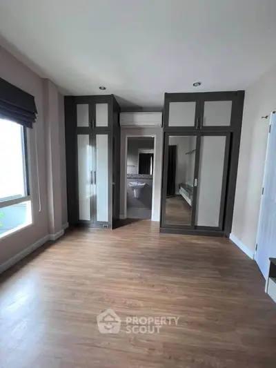 Spacious bedroom with elegant built-in wardrobes and large window