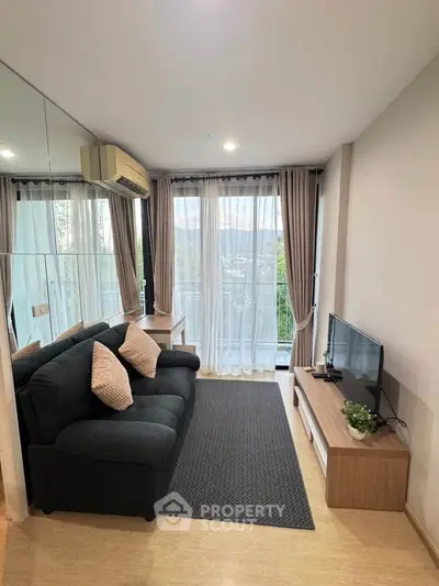 Modern living room with large windows and scenic view, featuring a cozy sofa and sleek TV setup.