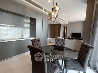 Modern open-layout kitchen and dining area with sleek design and elegant lighting.