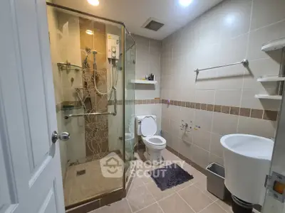 Modern bathroom with glass shower, stylish tiles, and sleek fixtures in a contemporary home.