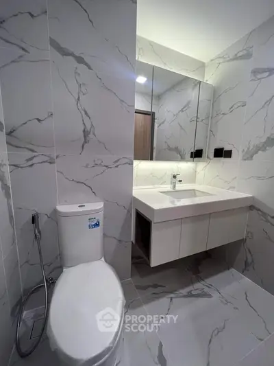 Modern bathroom with marble tiles and sleek fixtures in a contemporary apartment.