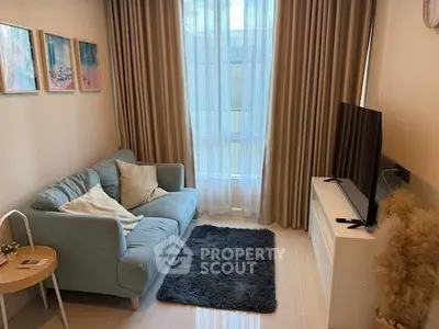 Cozy living room with plush sofa, large window, and modern TV setup.