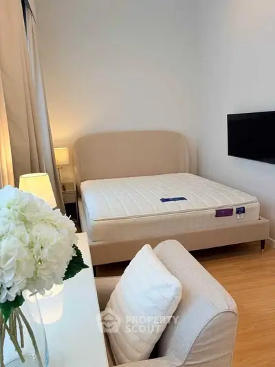 Cozy bedroom with modern decor, featuring a plush bed, elegant armchair, and ambient lighting.