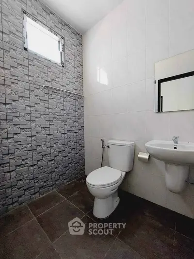 Modern bathroom with stone accent wall and sleek fixtures