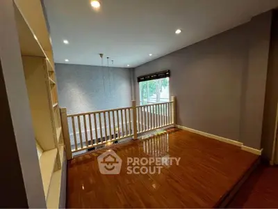 Spacious open loft area with wooden flooring and modern lighting, perfect for a cozy living space.