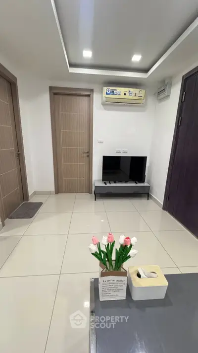 Modern living room with sleek design, featuring a wall-mounted air conditioner and minimalist decor.
